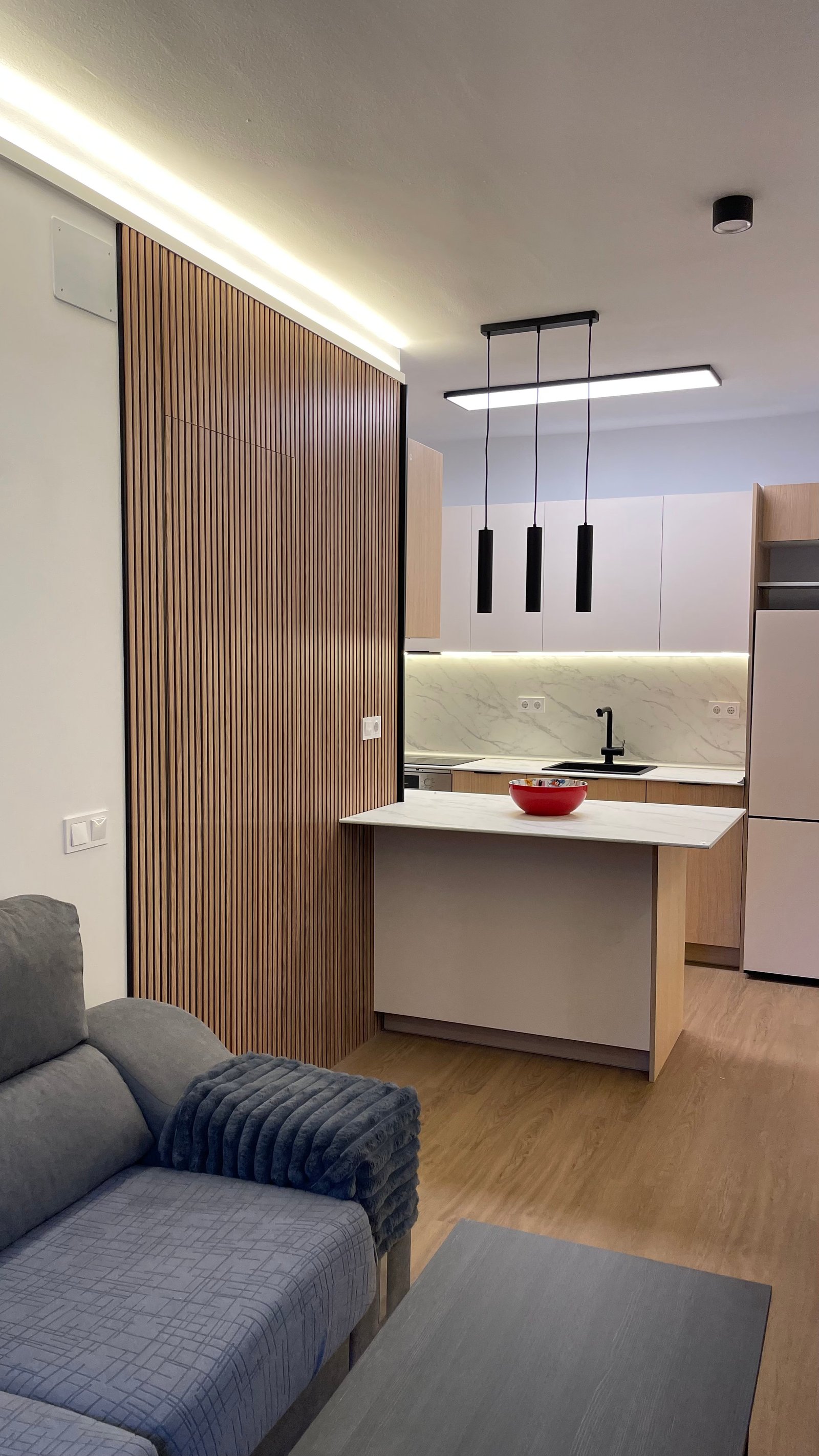 Salón y cocina abierta de la vivienda reformada en Rambla Guipúzcoa